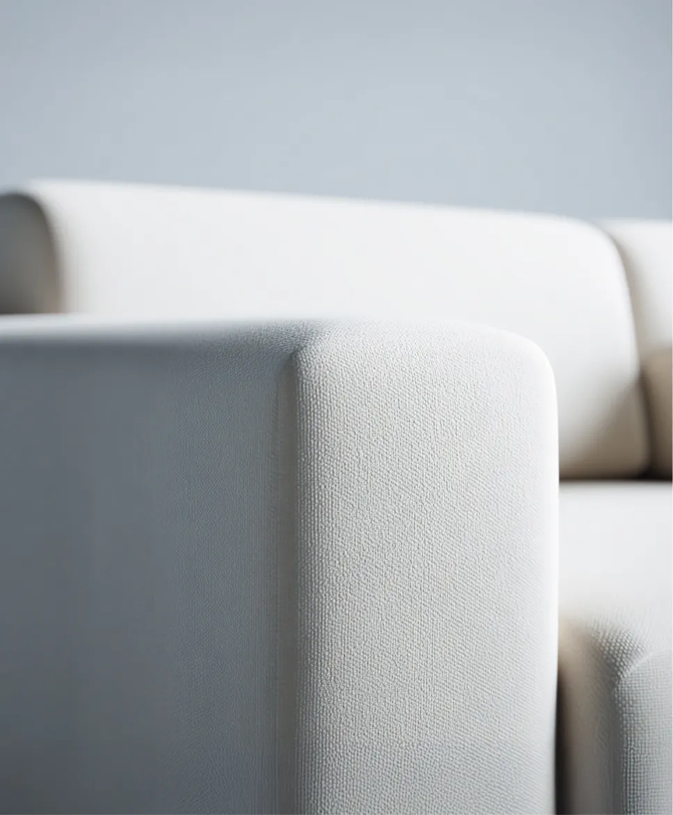 Primo piano del bracciolo di un divano bianco con tessuto testurizzato.